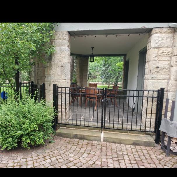 Iron gate with stone pillars and paver patio